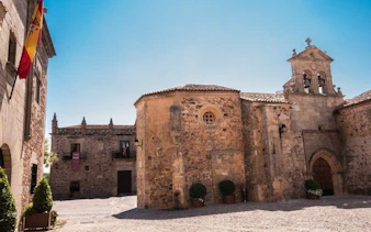 Cáceres historic stone buildings under clear sky on self-guided walking tour.