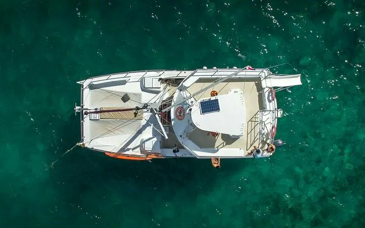 Catamaran on turquoise water, Punta Cana, for snorkeling cruise with open bar and snacks.