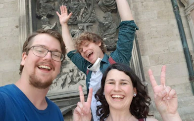 Visitors enjoying a self-guided exploration game in front of a historic Vienna landmark.