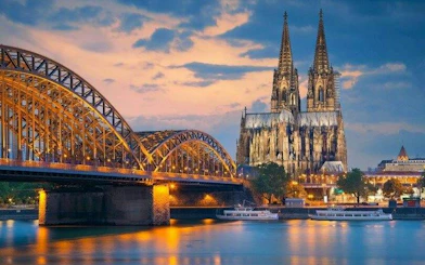 Cologne Cathedral and Hohenzollern Bridge at sunset, part of self-guided walking tour.
