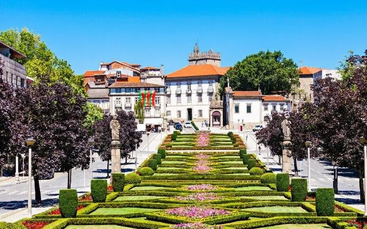 Guimaraes garden steps leading to historic buildings on a sunny day.