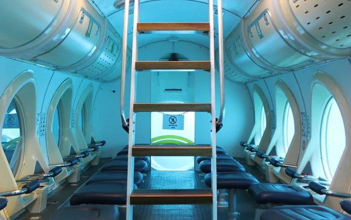 Interior of a submarine with seating and portholes, Tenerife Submarine Tour.