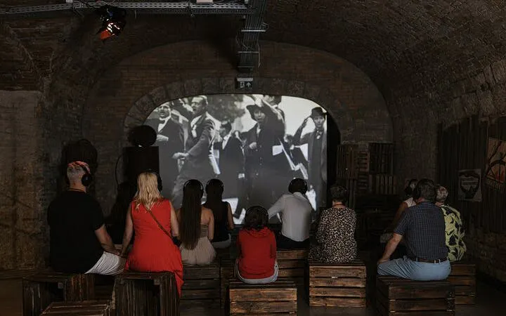 Visitors watching historical film at Time Machine Budapest exhibition.