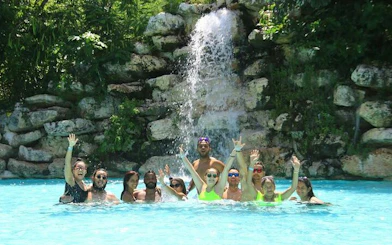 Group enjoying a swim in a jungle waterfall pool during Punta Cana horseback riding tour.