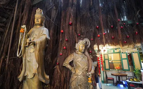 Statues under a banyan tree in Bang Rak, Bangkok, part of a cultural walking tour.