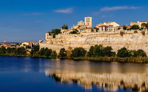 Zamora cityscape with historic buildings on a cliff above the Duero River.