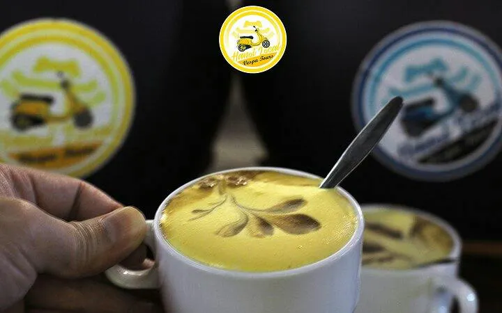 Egg coffee with decorative foam art in Hanoi during Vespa tour.