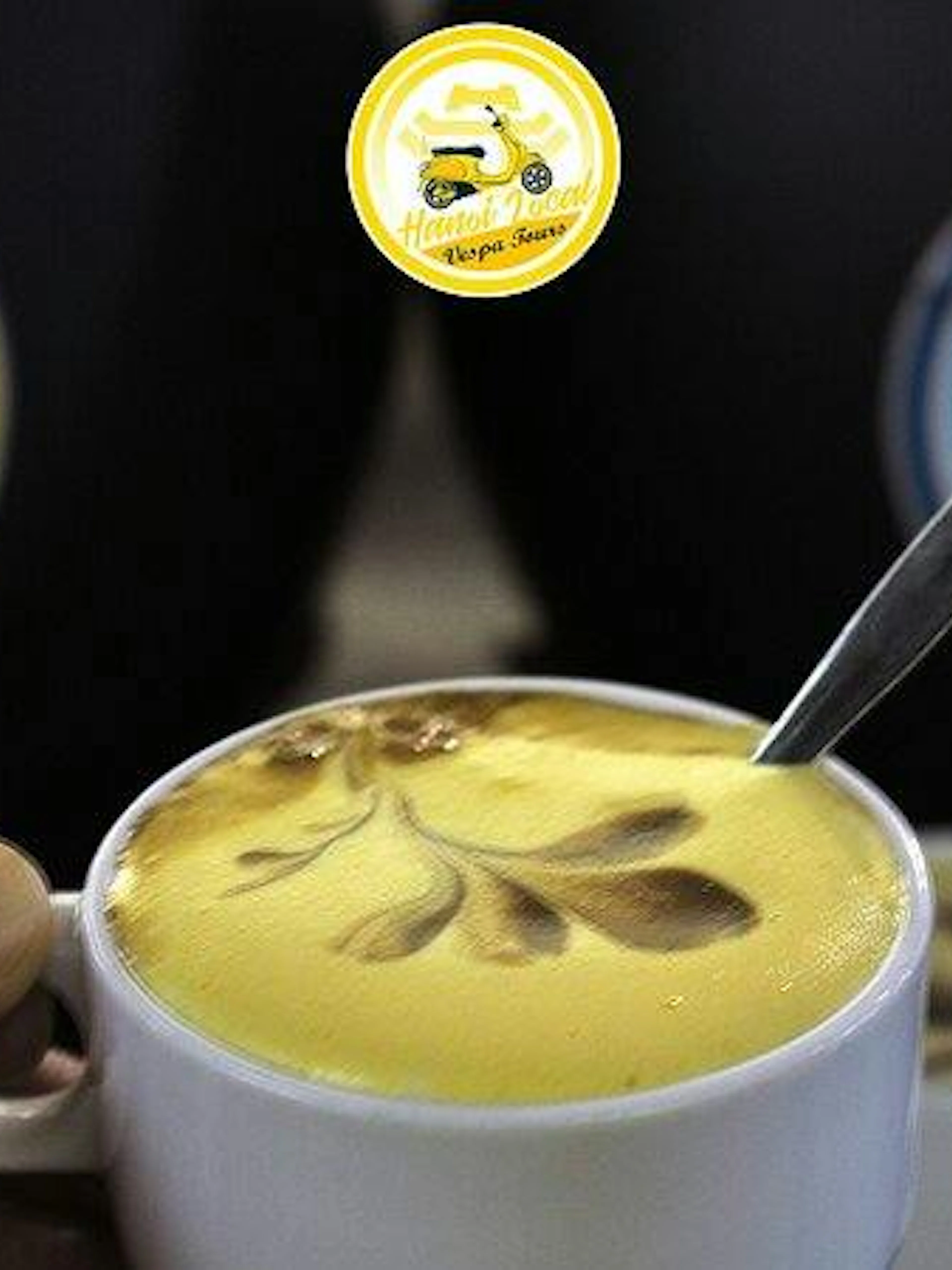 Egg coffee with decorative foam art in Hanoi during Vespa tour.