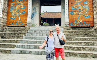 Visitors at Co Loa Citadel entrance, Hanoi, with traditional dragon murals.