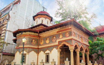 Stavropoleos Monastery in Old Town Bucharest with ornate frescoes and arches.