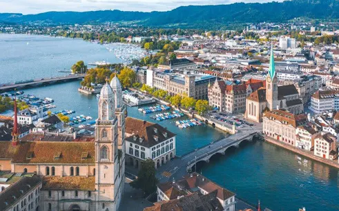 Zurich cityscape with Grossmünster and Limmat River, view from self-guided walking tour app.
