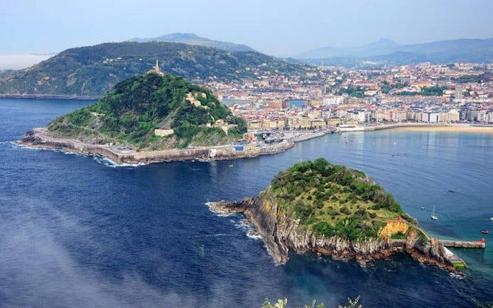 San Sebastian coastline with Monte Urgull and cityscape, view from self-guided walking tour.