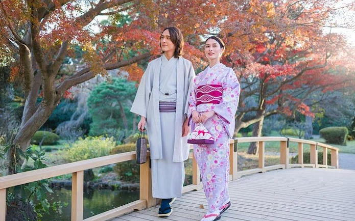 Kimono-clad visitors walking on a bridge in Shinjuku Gyoen National Garden, Tokyo.