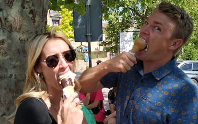 Couple enjoying gelato in San Gimignano during Tuscany day trip from Rome.