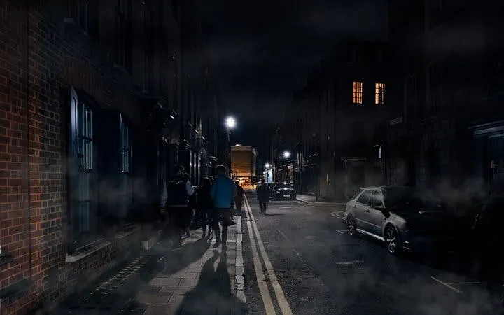 Group walking on a foggy street during York haunted history tour at night.