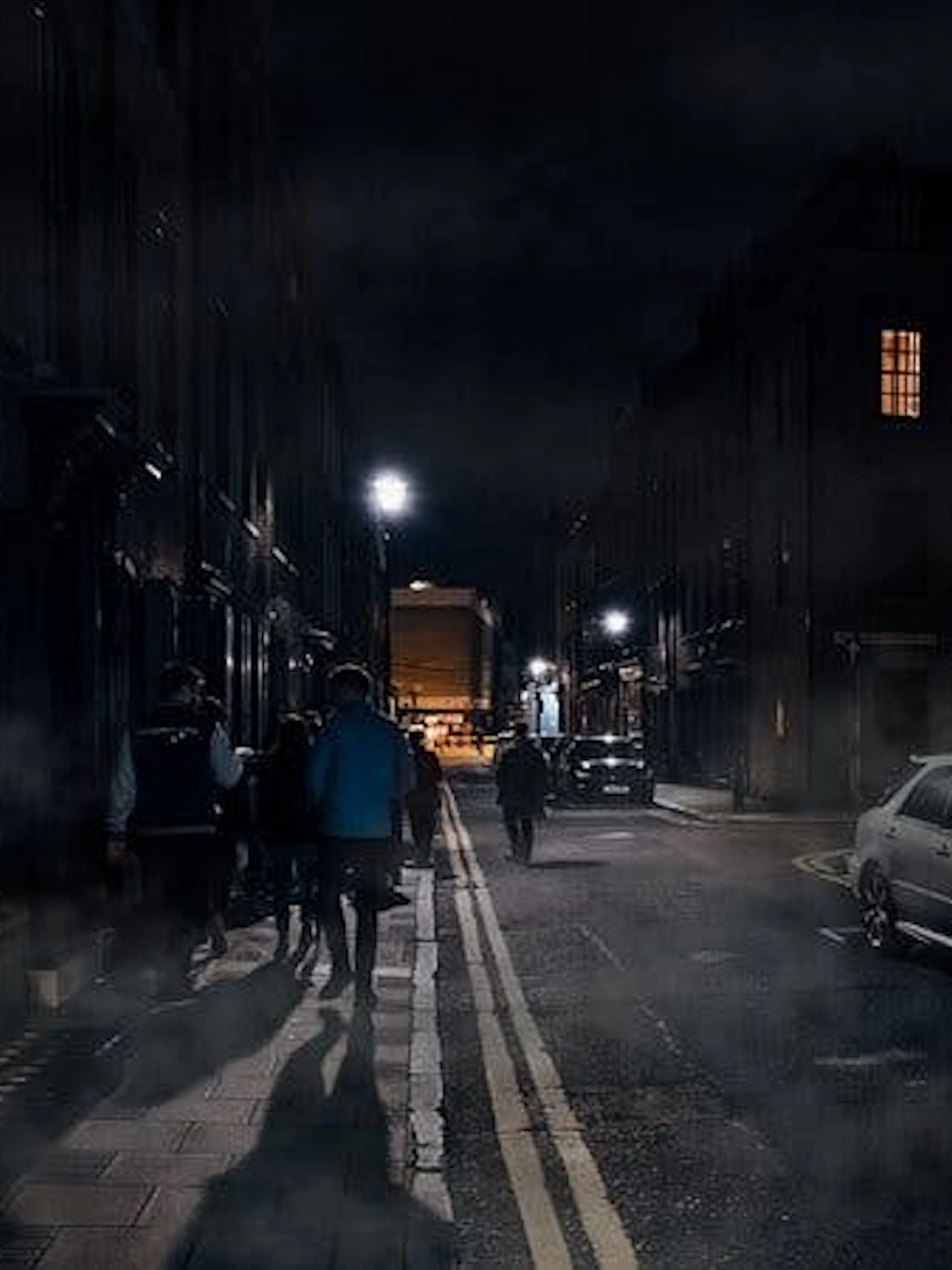 Group walking on a foggy street during York haunted history tour at night.
