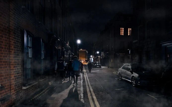 Group walking on a foggy street during York haunted history tour at night.