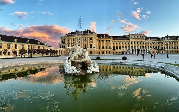 Schönbrunn Palace with Neptune Fountain in Vienna at sunset.