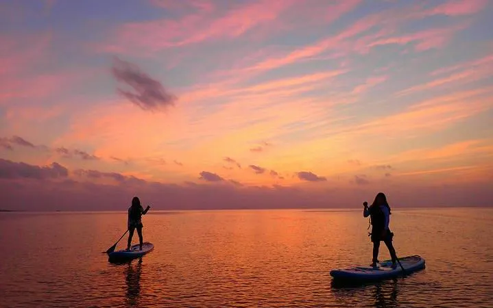 Paddleboarders on Ishigaki Island during sunset, Okinawa SUP tour.