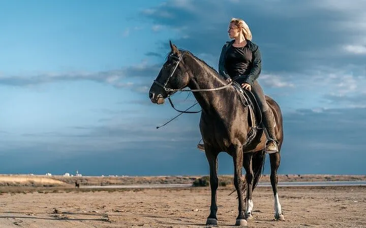 Horseback rider on sandy terrain with Red Sea backdrop in Hurghada.