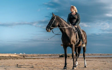 Horseback rider on sandy terrain with Red Sea backdrop in Hurghada.