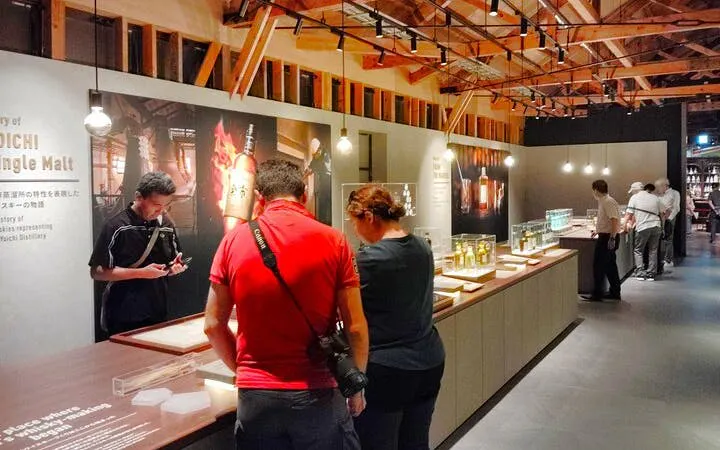 Visitors exploring whisky exhibits at Nikka's Yoichi distillery in Japan.