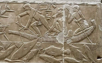 Ancient Egyptian fishermen in a boat carving, Model Village Egypt tour.