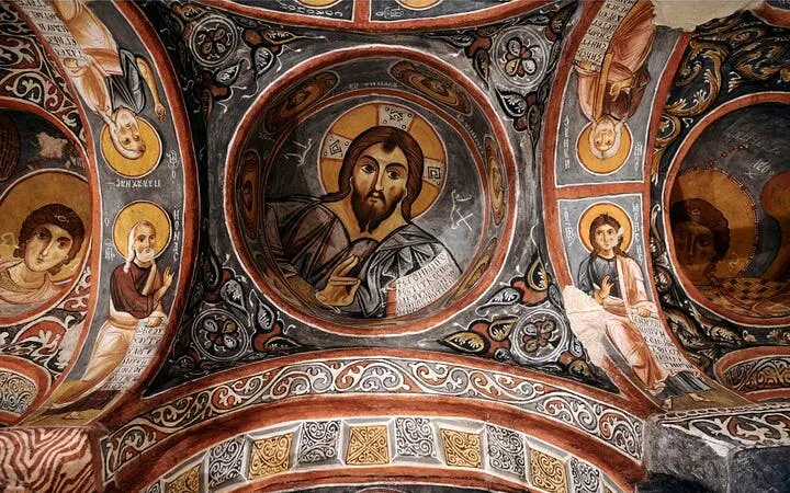 Ancient frescoes in a Cappadocia cave church, depicting religious figures and intricate designs.