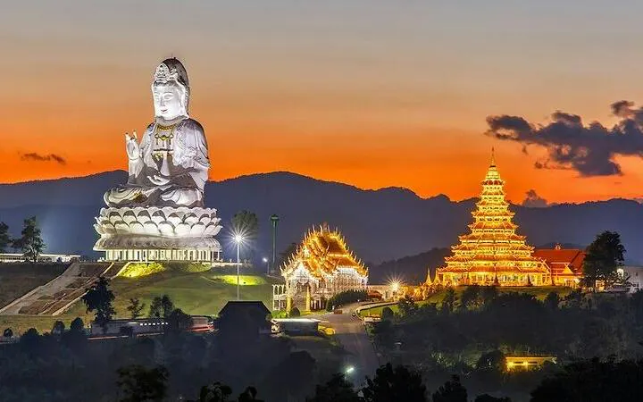 White Temple and illuminated pagoda at sunset, Chiang Rai City tour.