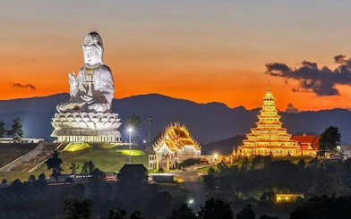 White Temple and illuminated pagoda at sunset, Chiang Rai City tour.