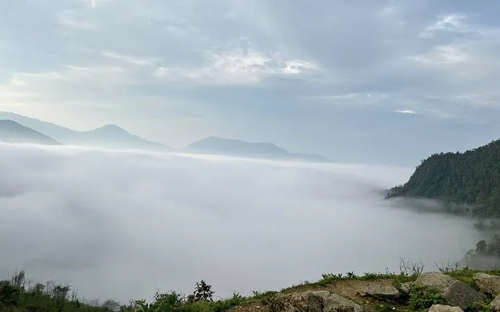 Foggy mountain landscape in Sapa with distant peaks and lush greenery.