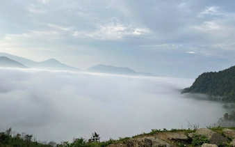 Foggy mountain landscape in Sapa with distant peaks and lush greenery.
