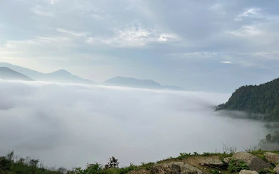 Foggy mountain landscape in Sapa with distant peaks and lush greenery.