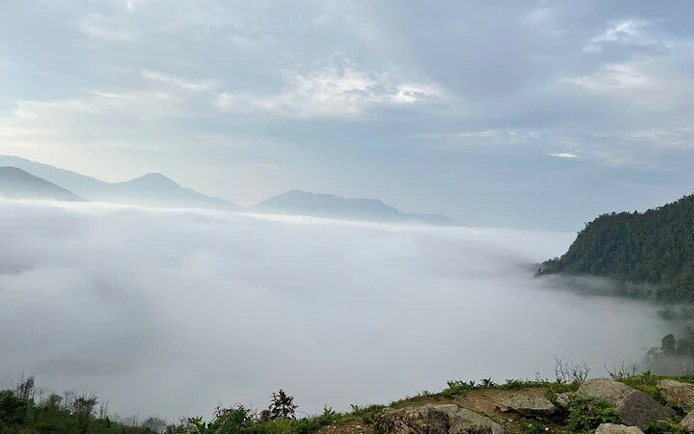 Foggy mountain landscape in Sapa with distant peaks and lush greenery.