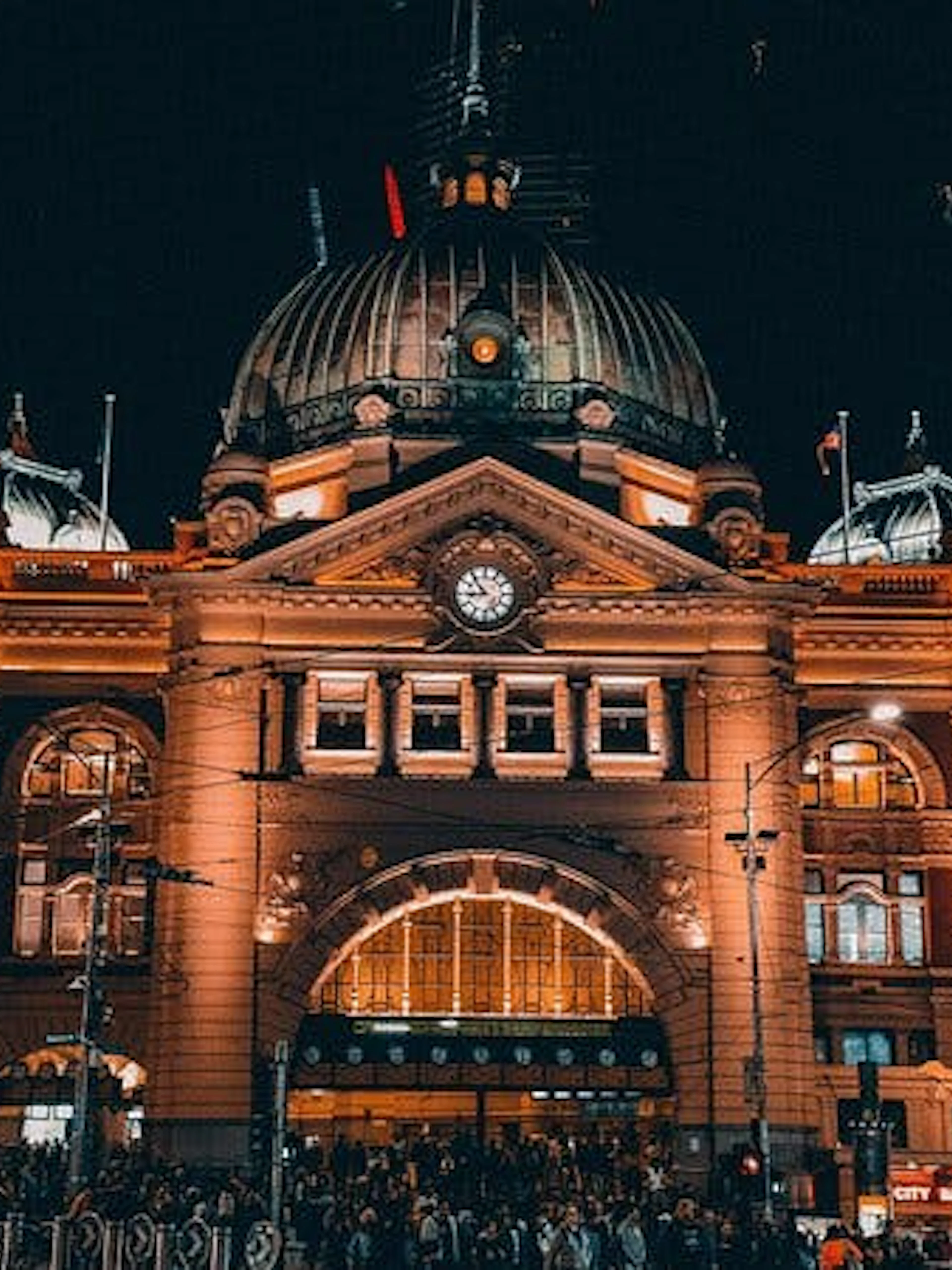 Flinders Street Station illuminated at night, part of Ghosts of Melbourne city exploration game.