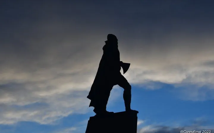 Statue silhouette against cloudy sky on Reykjavik walking tour.