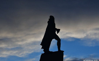 Statue silhouette against cloudy sky on Reykjavik walking tour.