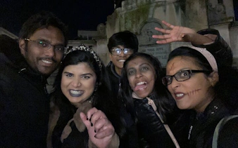 Group enjoying Haunted Liverpool city exploration game at night in a cemetery.