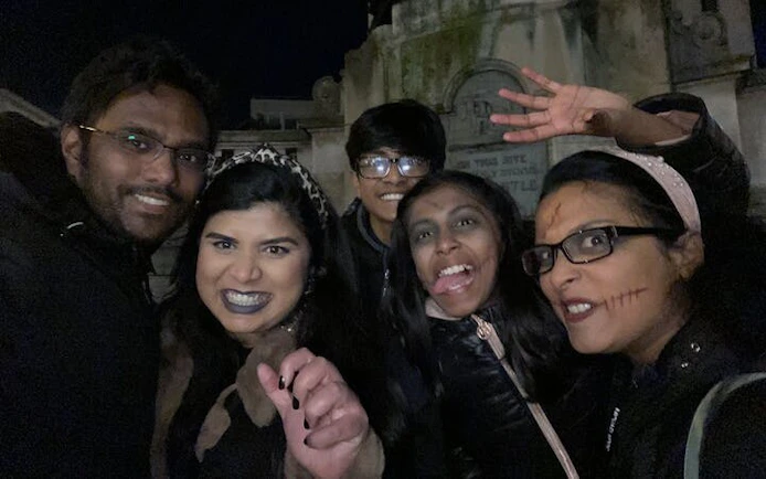 Group enjoying Haunted Liverpool city exploration game at night in a cemetery.