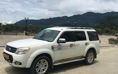 Sapa transport vehicle parked with mountain view, offering private door-to-door service to Mu Cang Chai.