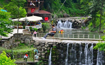 Guided tour in Sapanca with people enjoying a scenic waterfall view and lush greenery.