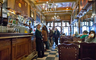 Lisbon café interior with patrons enjoying drinks during a historical city tour.