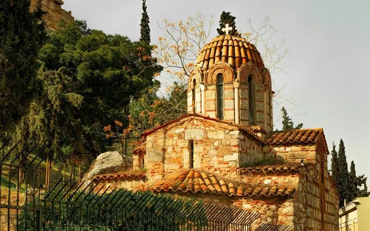 Byzantine church in Athens surrounded by trees on a self-guided walking tour.