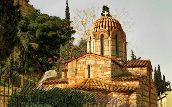 Byzantine church in Athens surrounded by trees on a self-guided walking tour.