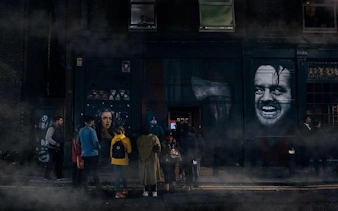 Group gathered outside a London building during Jack the Ripper walking tour with murals and fog.