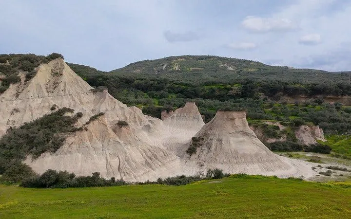 Balos Lagoon rock formations with greenery, part of a customizable day trip in Crete, Greece.