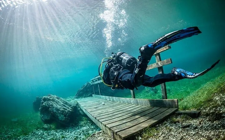 Scuba diver exploring underwater near a wooden walkway in Sharm El Sheikh.