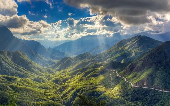 Sa Pa mountain landscape with winding road to O Quy Ho Pass under dramatic sky.