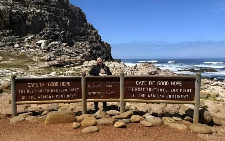 Cape of Good Hope sign with rocky coastline, part of Private Cape Peninsula tour.