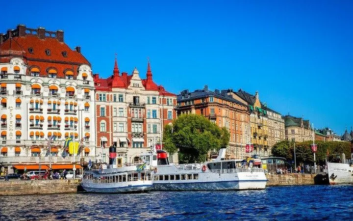 Stockholm waterfront with historic buildings and a tour boat, part of a self-guided walking tour.